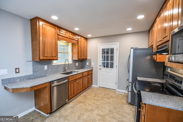 kitchen featuring light stone counters, sink, decorative backsplash, and appliances with stainless steel finishes