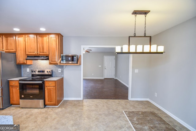 kitchen with hanging light fixtures, stainless steel appliances, and tasteful backsplash