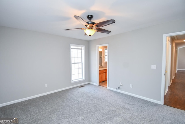 unfurnished bedroom with light carpet, ceiling fan, and ensuite bathroom