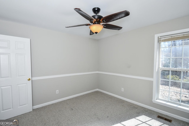 empty room featuring ceiling fan and light colored carpet