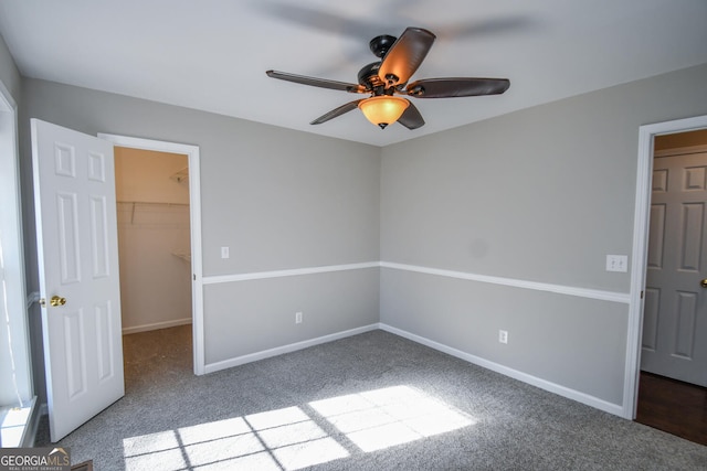 unfurnished room with ceiling fan and carpet