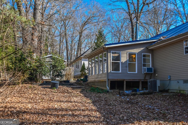 view of property exterior with a sunroom and cooling unit