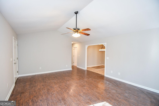 unfurnished room with ceiling fan, vaulted ceiling, and dark hardwood / wood-style floors