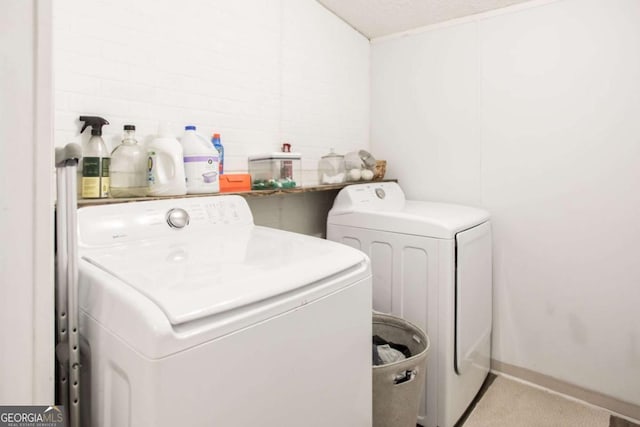 laundry room with a textured ceiling and washing machine and clothes dryer