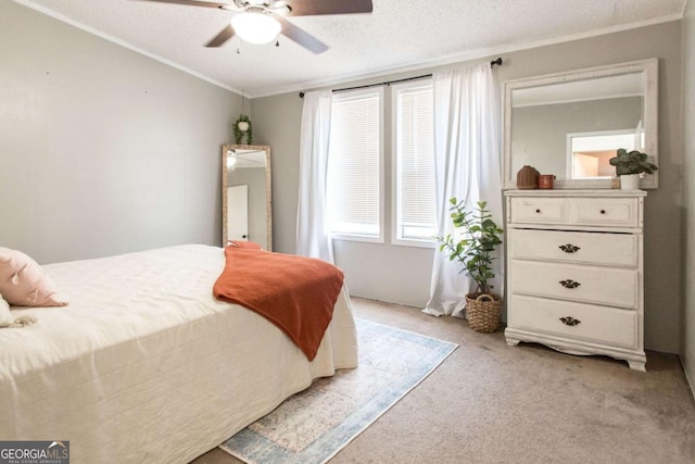 carpeted bedroom featuring ceiling fan, a textured ceiling, and ornamental molding