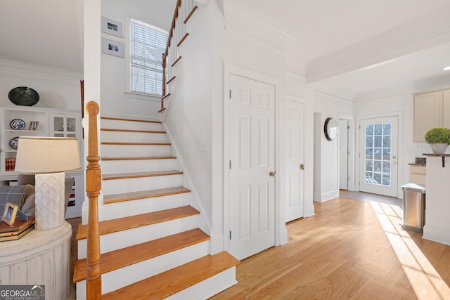 stairs with crown molding and hardwood / wood-style floors