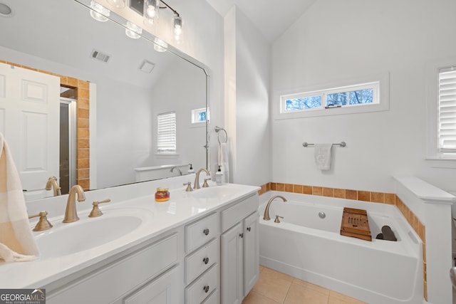 bathroom featuring plus walk in shower, vanity, lofted ceiling, and tile patterned flooring