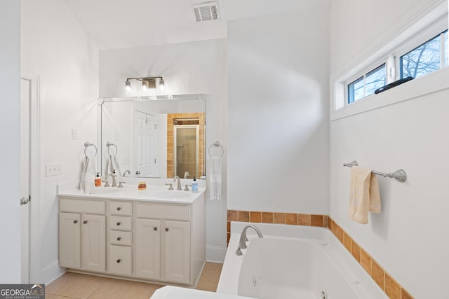 bathroom featuring vanity, tile patterned floors, and plus walk in shower