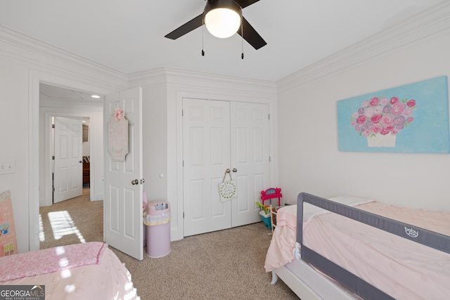 carpeted bedroom with ceiling fan, a closet, and crown molding