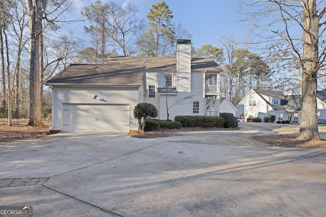 view of side of home featuring a balcony and a garage