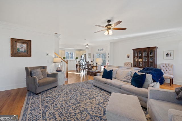 living room featuring ceiling fan, ornamental molding, and hardwood / wood-style floors