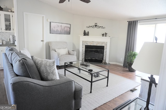 living room featuring ceiling fan, a fireplace, and hardwood / wood-style floors