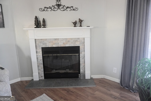 details with wood-type flooring and a tiled fireplace