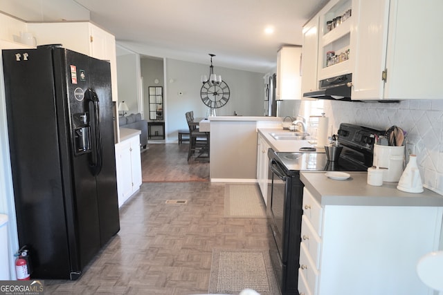 kitchen with sink, white cabinets, hanging light fixtures, and black appliances