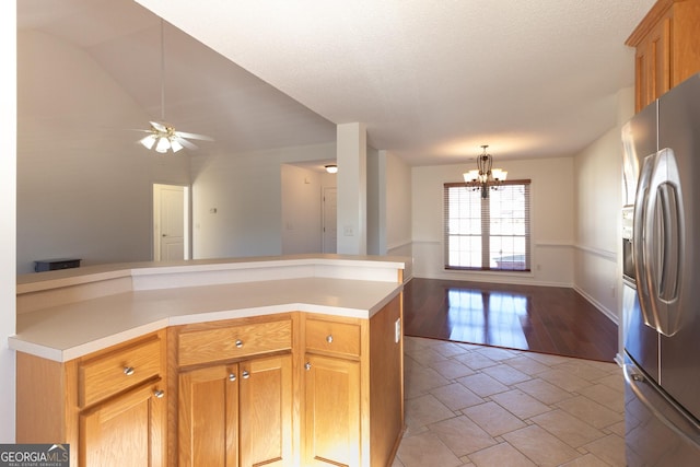 kitchen with ceiling fan with notable chandelier, stainless steel fridge, and a textured ceiling