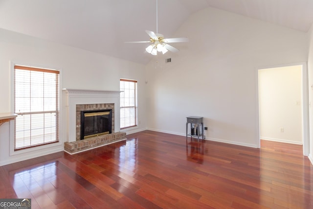 unfurnished living room featuring ceiling fan, a brick fireplace, dark hardwood / wood-style floors, and high vaulted ceiling