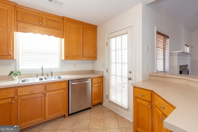 kitchen featuring a healthy amount of sunlight, sink, light tile patterned floors, and dishwasher