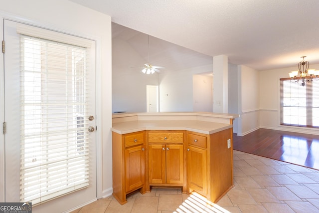 kitchen featuring ceiling fan with notable chandelier, a textured ceiling, and light tile patterned floors