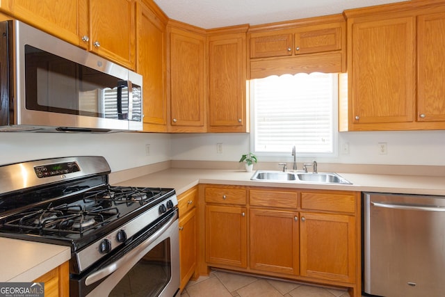 kitchen with light tile patterned flooring, appliances with stainless steel finishes, and sink