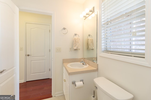 bathroom with vanity, toilet, and hardwood / wood-style floors