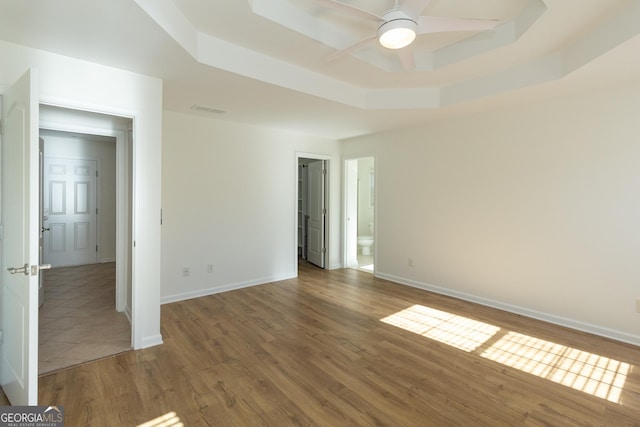 spare room with hardwood / wood-style flooring, ceiling fan, and a tray ceiling