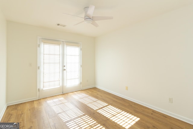 unfurnished room featuring french doors, ceiling fan, and light hardwood / wood-style flooring