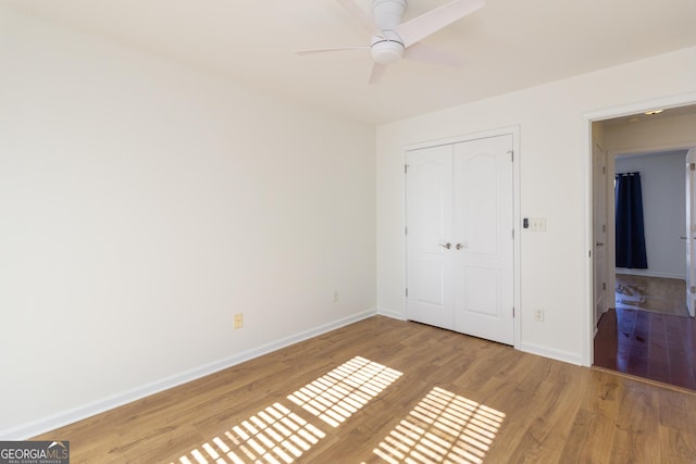 unfurnished bedroom with ceiling fan, a closet, and light hardwood / wood-style flooring