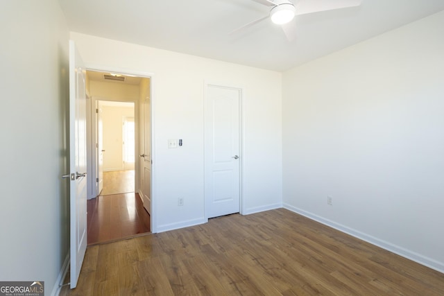 unfurnished bedroom featuring ceiling fan and dark hardwood / wood-style floors