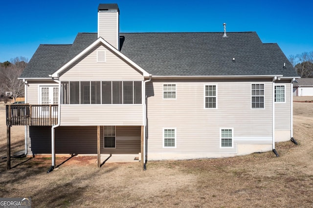 rear view of house featuring a sunroom, a yard, and a deck