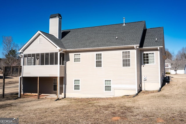 back of house featuring a yard and a sunroom