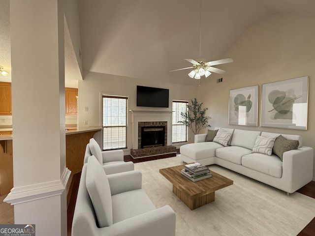 living room with ceiling fan, high vaulted ceiling, and a brick fireplace