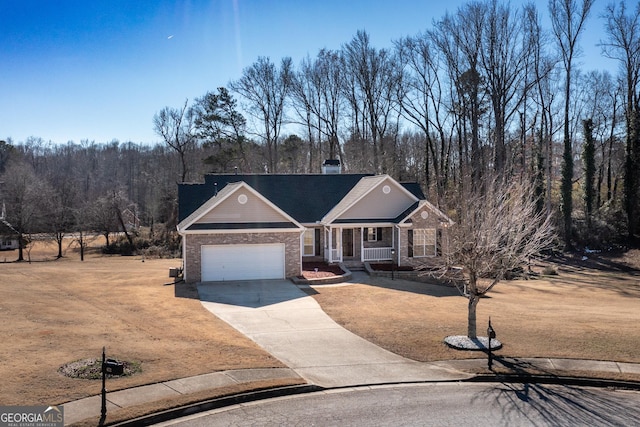 view of front of property with a garage, covered porch, and a front lawn