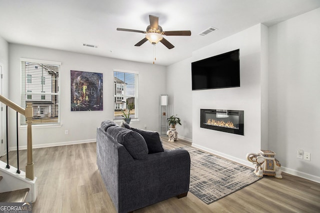 living room featuring ceiling fan and light hardwood / wood-style flooring