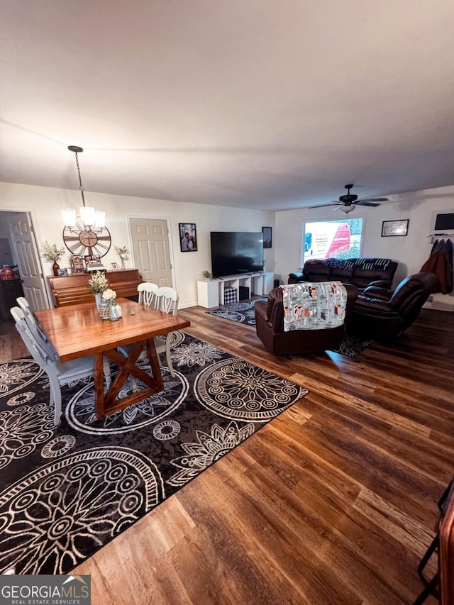 living room featuring ceiling fan with notable chandelier and wood-type flooring