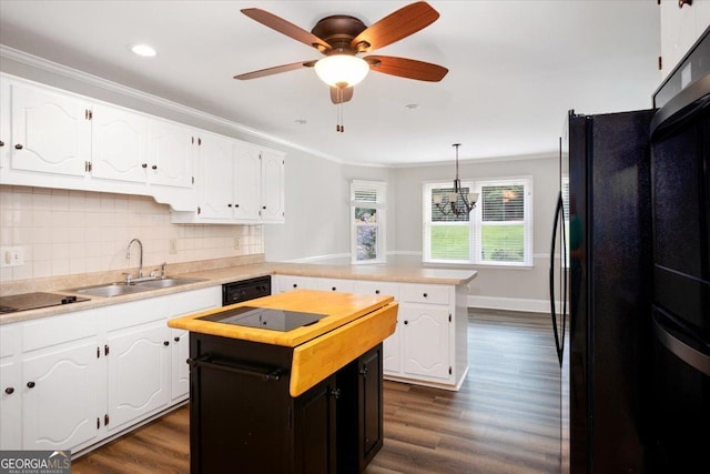 kitchen with a kitchen island, white cabinetry, hanging light fixtures, and sink