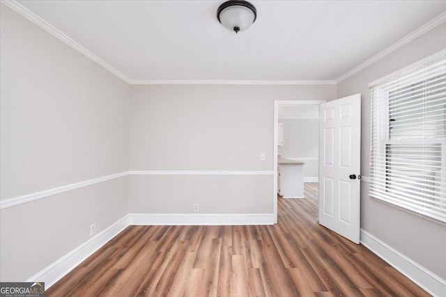 spare room with plenty of natural light, crown molding, and dark hardwood / wood-style floors