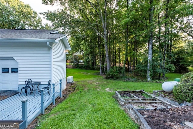 view of yard featuring a garage and central AC