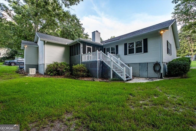 back of house featuring a sunroom and a yard