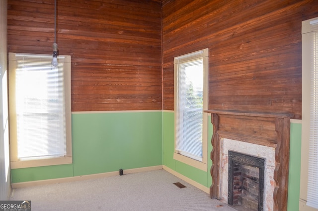 interior space with carpet floors, a fireplace, and wooden walls