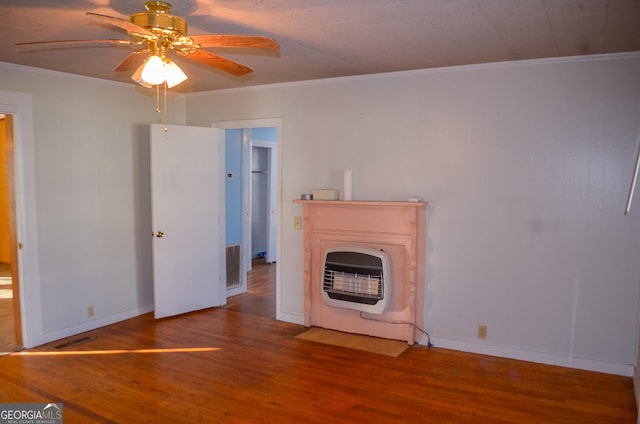 unfurnished living room with hardwood / wood-style flooring, heating unit, crown molding, and ceiling fan