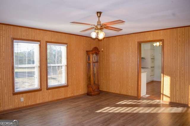 unfurnished room with ceiling fan, wood-type flooring, and crown molding