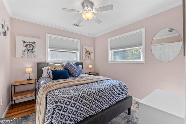 bedroom featuring ceiling fan, ornamental molding, and wood-type flooring