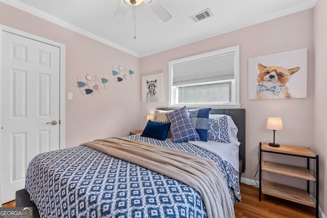 bedroom featuring ceiling fan, hardwood / wood-style flooring, and crown molding