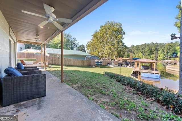 view of patio featuring a water view, ceiling fan, and a gazebo