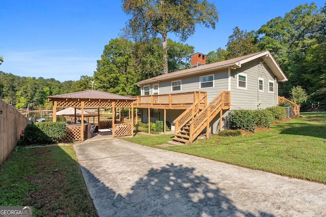 view of front facade with a front yard, a wooden deck, and a gazebo