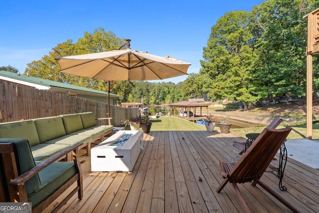 wooden deck with an outdoor living space with a fire pit