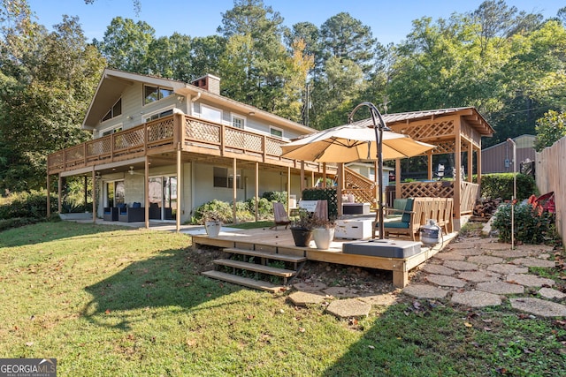 back of house featuring a hot tub, a deck, a patio, and a yard