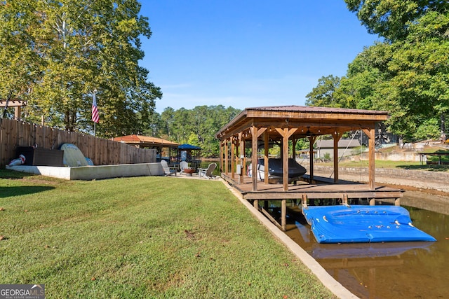 dock area with a water view and a yard