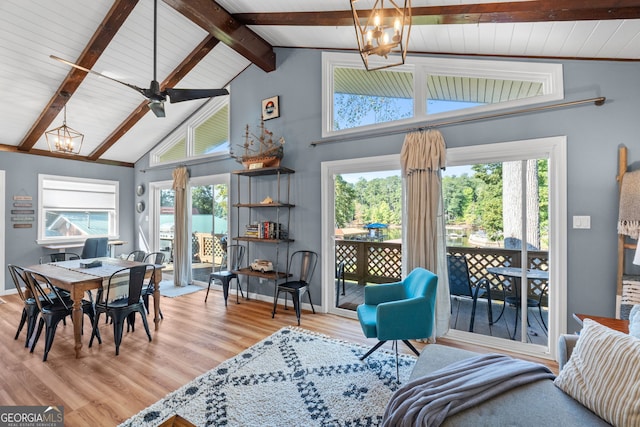 living room with light hardwood / wood-style floors, high vaulted ceiling, beam ceiling, and ceiling fan with notable chandelier