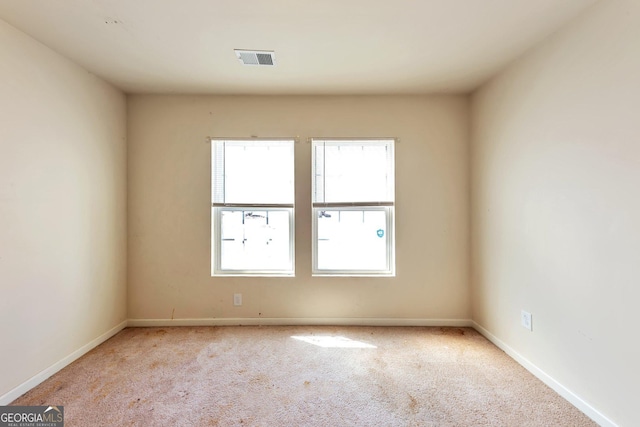 carpeted empty room with visible vents and baseboards